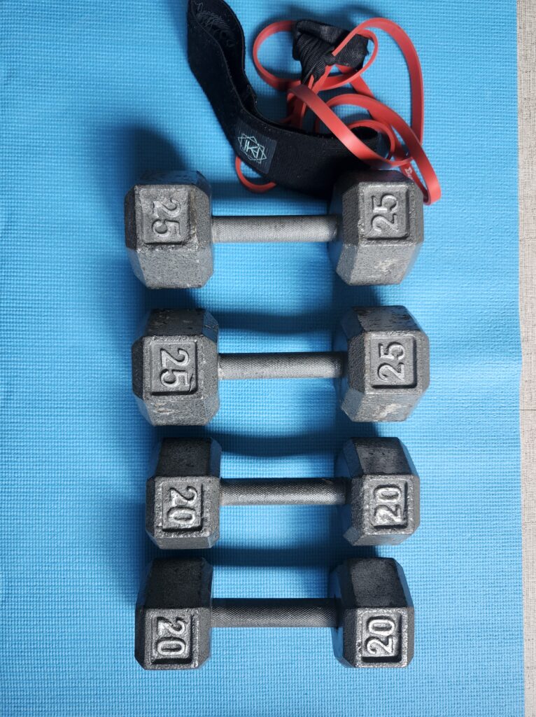 Set of free weights and bands on a yoga mat. Perfect for women building strength after 40