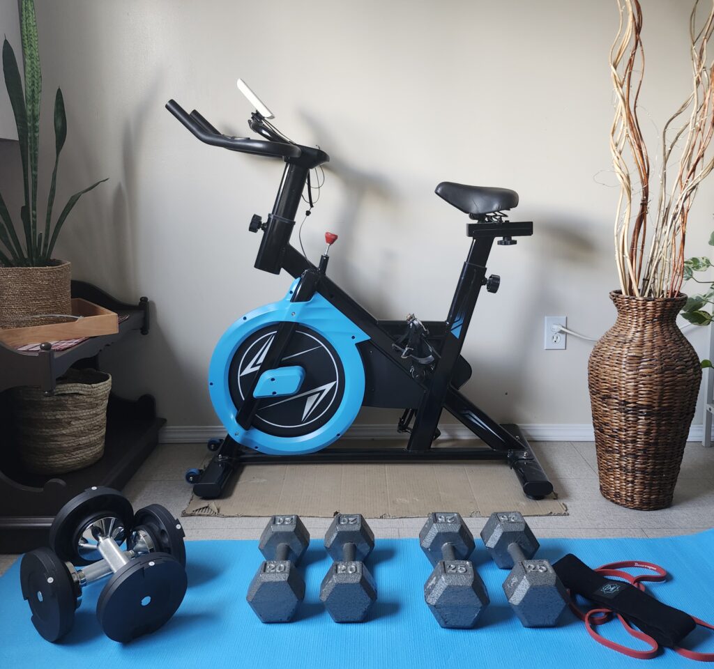 Exercise bike, free weights and bands in a cozy home gym space for energizing low-impact cardio