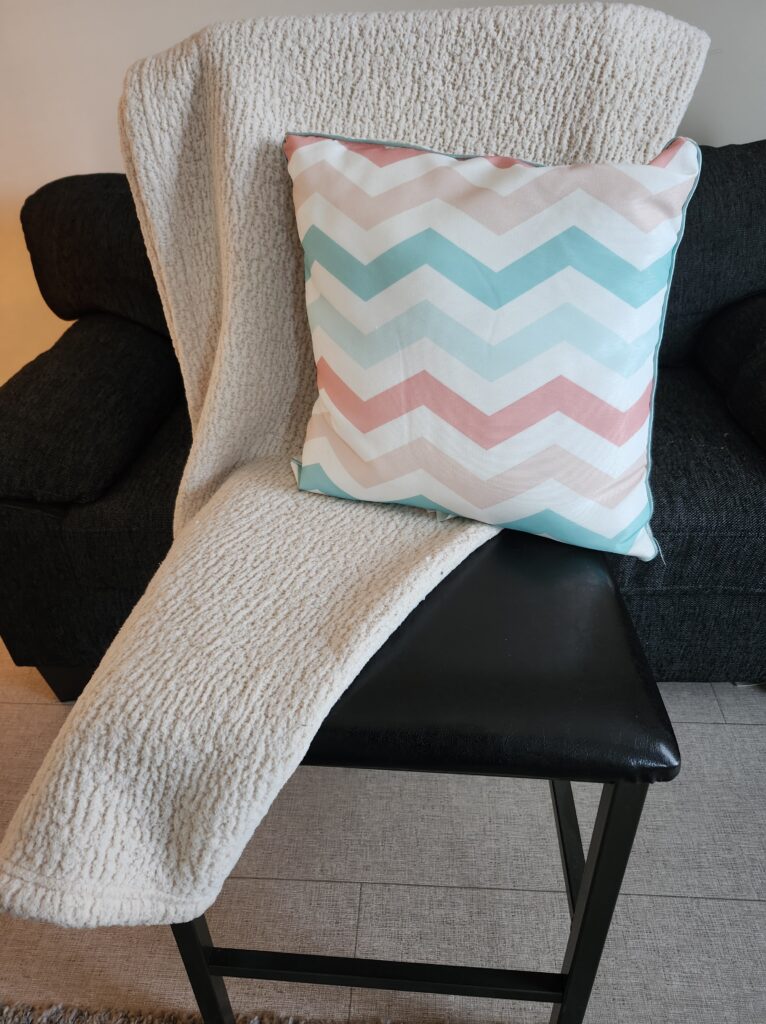 Cozy nook in the living room with a cozy chair, pillow and blanket